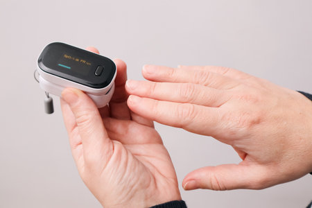 Woman using fingertip pulse oximeter. Monitoring Blood Oxygen Levels and Pulse Rateの写真素材