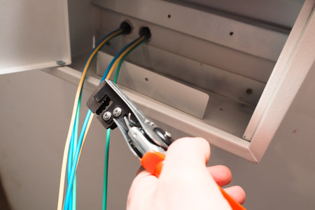 Installation of electrical panel. Electrical switchboard with wires. Electrician working with work toolの写真素材