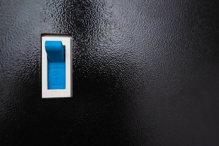 Turning off the power. Single-pole circuit breaker on black. Electrical background.の写真素材