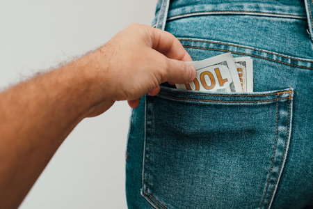 Money in the pocket. Concept finance with Bundle of dollars. Human hand taking money from jeans pocket.の写真素材
