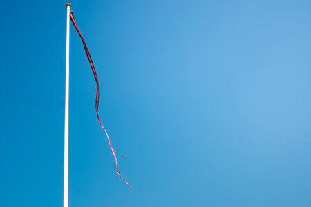 Wind flag flying in the wind on blue sky.の写真素材