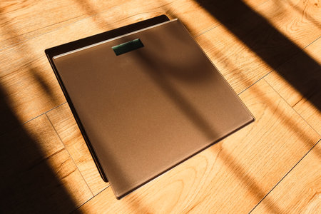 Bathroom scales for weight loss concept on wooden sunny background rear view. Weight scale.の写真素材