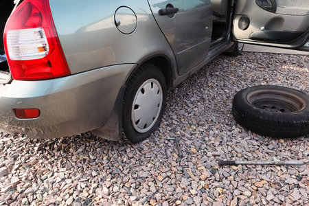 Car wheel low air pressure. Auto repair tires. Car with punctured car tires on a road. Focus on a wheel. Forced emergency stop on the side of roadside, burst tire.の写真素材