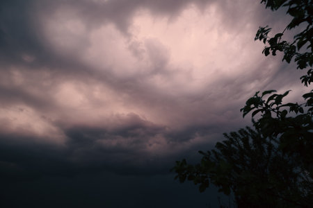 Beautiful colorful stormy sky at sunset. Sunset with mood stormy sky. A dramatic sunset breaking through stormy clouds.の写真素材