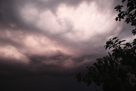 Beautiful colorful stormy sky at sunset. Sunset with mood stormy sky. A dramatic sunset breaking through stormy clouds.の写真素材
