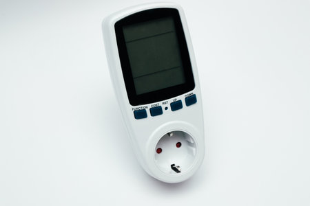 Wattmeter for measuring electricity costs, close-up on white background.の写真素材