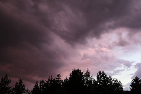 Beautiful colorful stormy sky at sunset. Sunset with mood stormy sky. A dramatic sunset breaking through stormy clouds.の写真素材