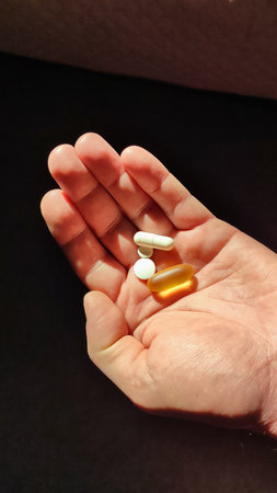 Pills, medicine and healthcare of senior man taking daily capsules and pills. Medication health care medical concept. Close up hand man taking multiple pills take a medicine in handの写真素材