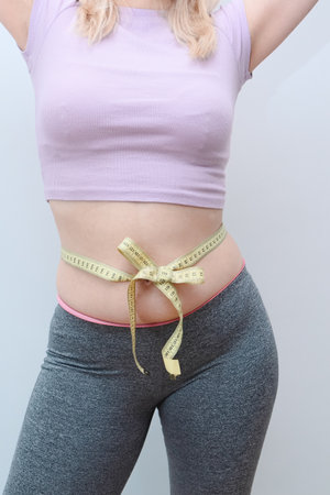 Unrecognizable lady checking result of weight loss diet or liposuction. Overweight woman measuring...
