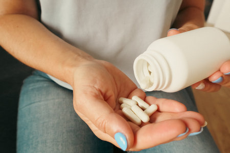 Woman taking vitamins or pills for treatment at home. Woman taking vitamins and supplements. Medical...