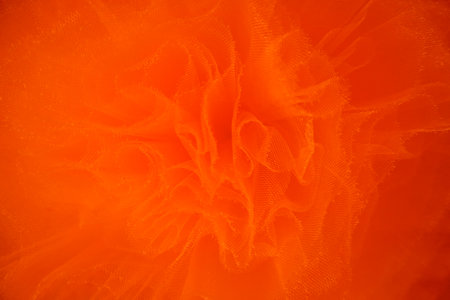 Red silk fabric drapes, elegant waves, background, textile design. A close-up shot of a red color satin fabric, showing its smooth, glossy textureの写真素材