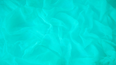 Close-up of blue silk fabric with soft folds and drapery. Perfect as an abstract background for...