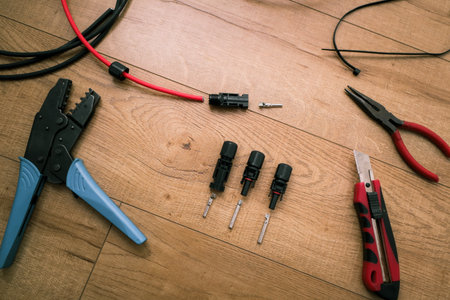 Solar panel wiring tools. Wire, connectors, crimping pliers on wooden floor.の写真素材