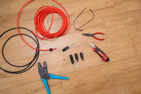 Solar panel wiring tools. Wire, connectors, crimping pliers on wooden floor.の写真素材