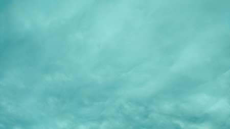 Abstract turquoise sky background with soft, blurry cloud patterns. Minimalistic atmospheric texture ideal for design, presentations, and creative projects.の写真素材
