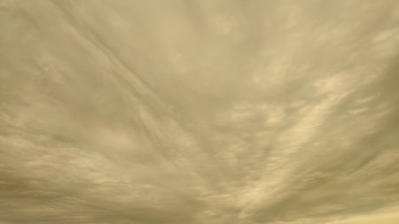 A dramatic, full-frame view of a dull, overcast sky dominated by swirling gray and white altostratus...