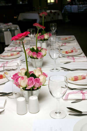 wedding table setting with pink and white roses and pink daisies