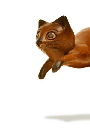 Wooden cat statue caught in a playful pounce. Clipping path included.の写真素材