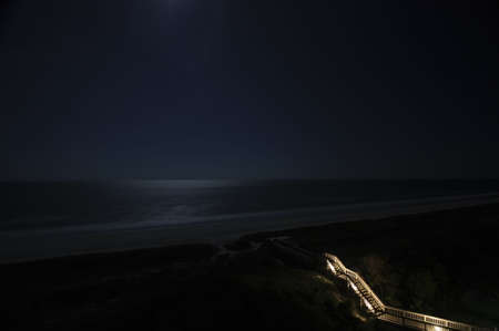 Tiny beach stairway, vast night skyの写真素材