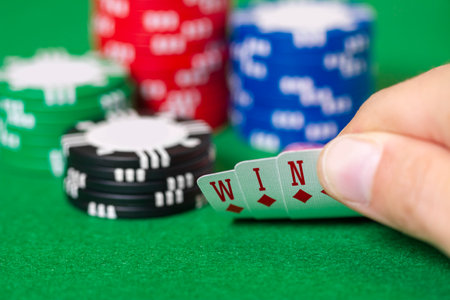 Fingers hold cards that spell WIN, with chips, gambling, poker, blackjack or Texas Hold 'Em in Las...