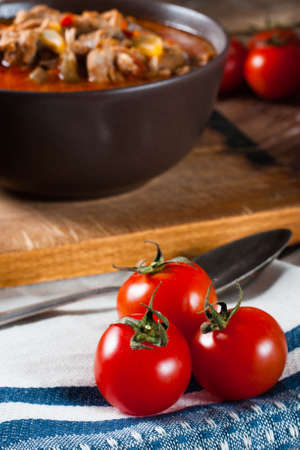 Goulash soup with paprika and cucumber in a bowl.