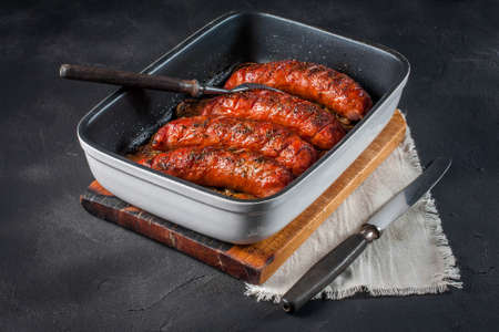 Sausages baked with onion rings in brytfance. with onion rings in brytfance.の写真素材