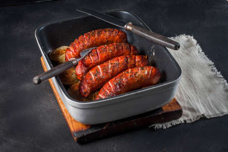 Sausages baked with onion rings in brytfanceの写真素材