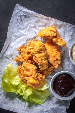 Hot breaded pieces of chicken with two sauces.の写真素材