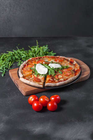 Vegetarian pizza with mozzarella arugula and cherry tomatoes.の写真素材