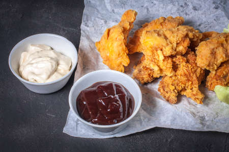 Hot breaded pieces of chicken with two sauces.の写真素材