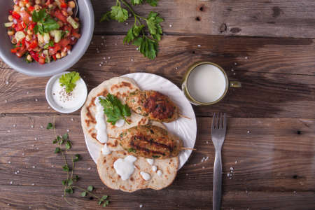 Turkish kofta with flatbread on a plate. Salad and ayran in the backgroundの写真素材