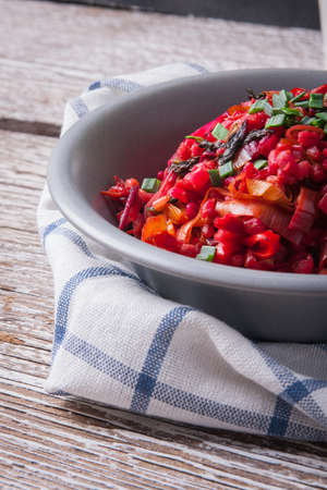 Bowl of buckwheat groats with vegetables and glass of orange juice on wooden tableの写真素材