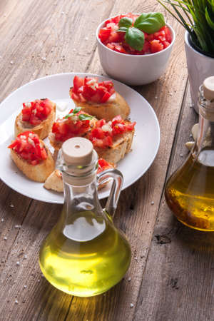 Plate of bruschetta with tomato, onion and basil on a wooden tableの写真素材