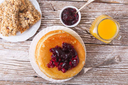 Stack of pancakes on a plate with glass of orange juice and breakfast barsの写真素材