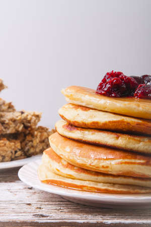 Stack of pancakes on a plate with glass of orange juice and breakfast barsの写真素材