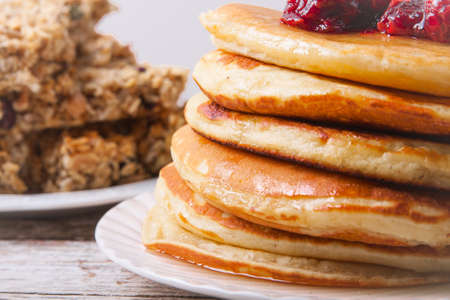 Stack of pancakes on a plate with glass of orange juice and breakfast barsの写真素材