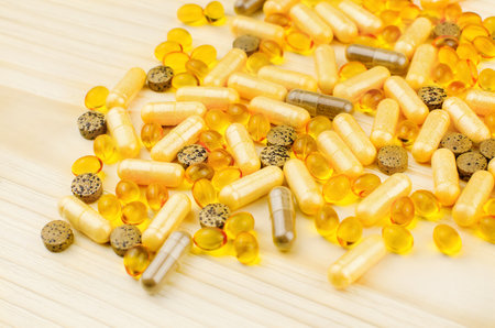Variety of dietary supplements and vitamin pills on wooden background, alternative medicine conceptの写真素材
