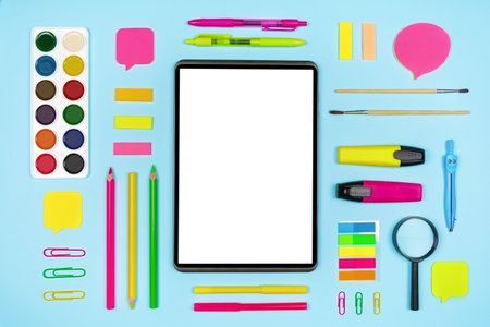 Various colorful stationery and digital tablet with blank display on blue background. Top view with copy spaceの写真素材