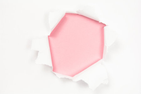 Torn white paper with hole on pink paper background, copy spaceの写真素材