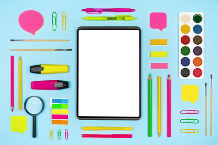 Various colorful school supplies and digital tablet with blank display on blue background. top view with copy spaceの写真素材