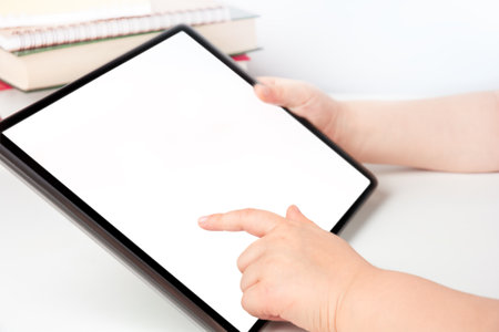 Child's hands holding digital tablet and touching blank screen, e-learning conceptの写真素材