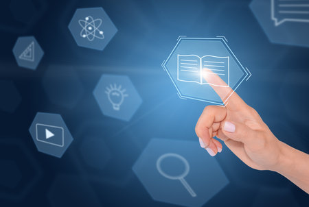 E-learning technology, education concept. Woman's finger touching virtual digital screenの写真素材