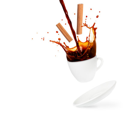 Pouring and splashing coffee with cinnamon sticks isolated on white backgroundの写真素材