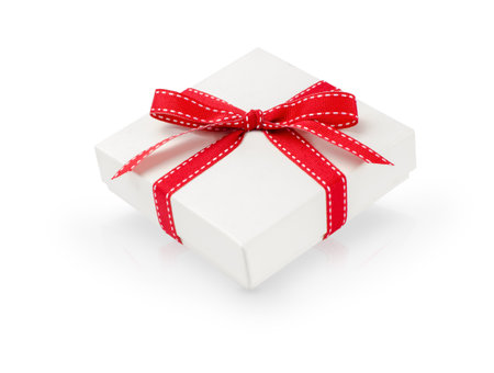 Small white gift box with red ribbon isolated on whiteの写真素材