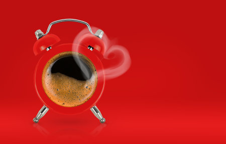 Alarm clock with coffee and steam in the heart shape on red background, copy space. Loving coffee or Valentines day celebration conceptの写真素材