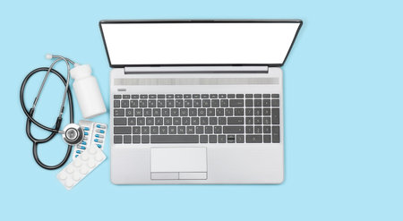 Laptop with empty display, stethoscope and remedy on blue background, top view with copy spaceの写真素材