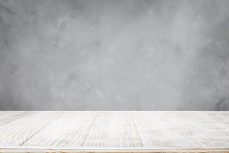 White wooden table with gray concrete wall backgroundの写真素材