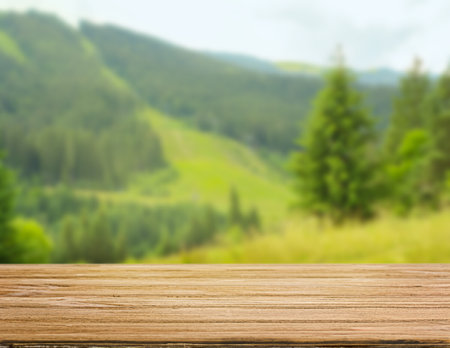 Wooden table with mountain scene background on summer dayの写真素材
