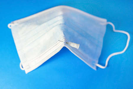 A blue mask with a blue background and a syringe for injection for healthcare workers and people at...