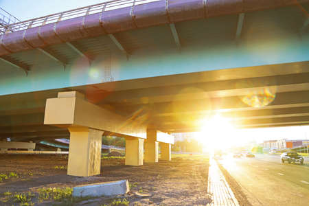 city bridge for viaduct cars for avoiding traffic jams by cars in dense city traffic. shot against the sun with haresの写真素材